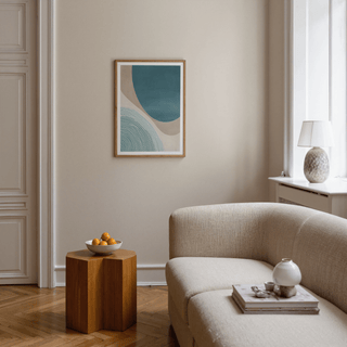 Modern Minimalist Print with abstract blue shapes framed on a beige wall above a wooden side table with a bowl