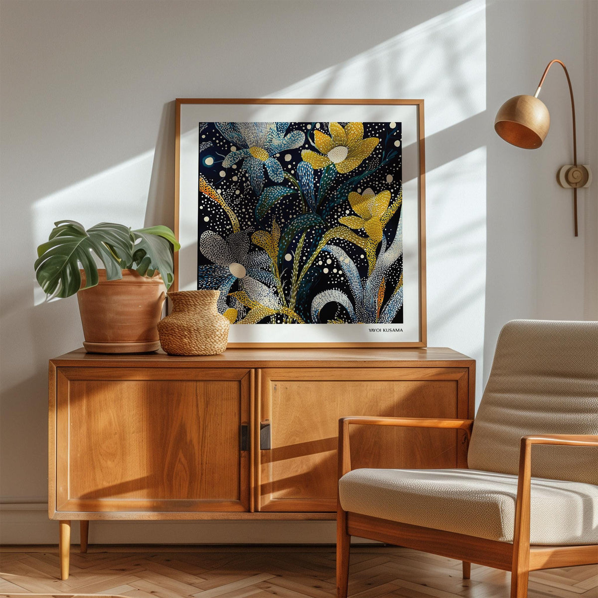 Dark floral wall art with yellow and blue abstract flowers above a wooden sideboard in a bright room