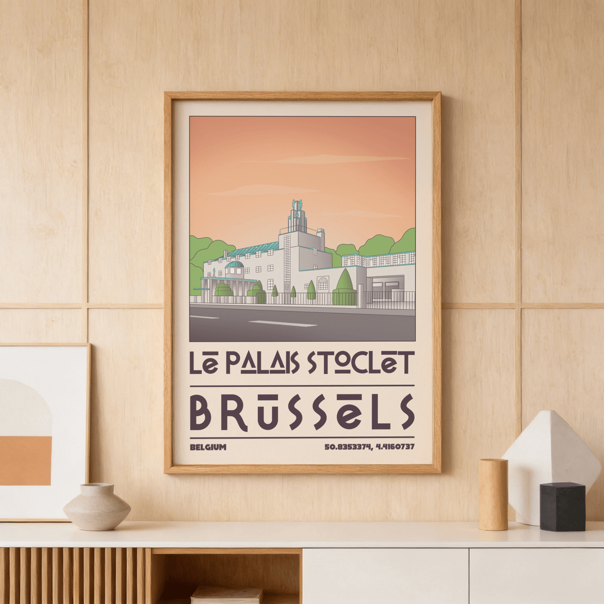 Framed Art Deco Brussels print of Palais Stoclet in muted peach and green on a wood panel wall