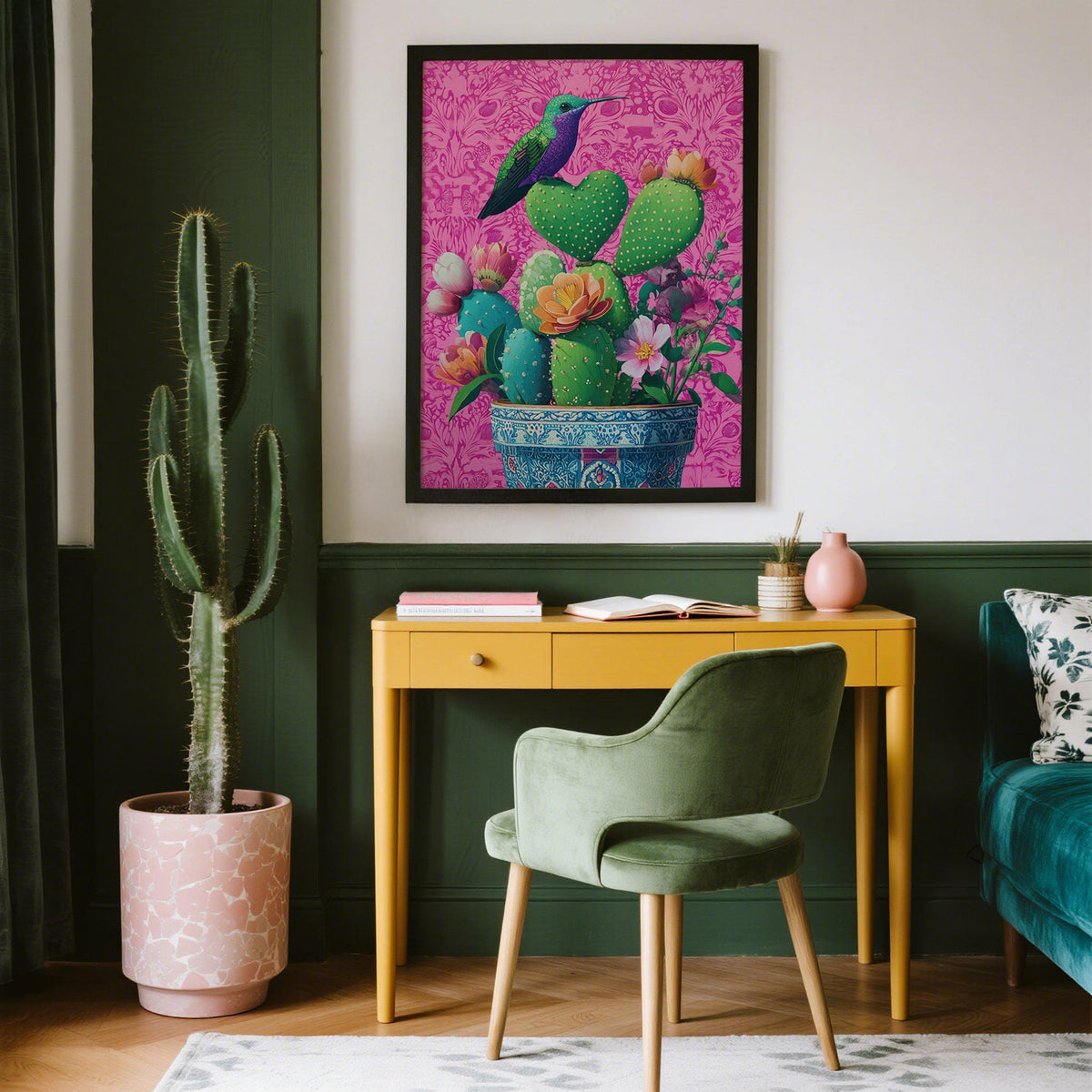 Print in dark frame of heart shaped cactus with pink detail on wall above yellow desk in living room