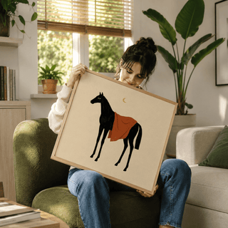 Framed Horse Moon wall art of a black horse with an orange blanket held by a woman on a green armchair