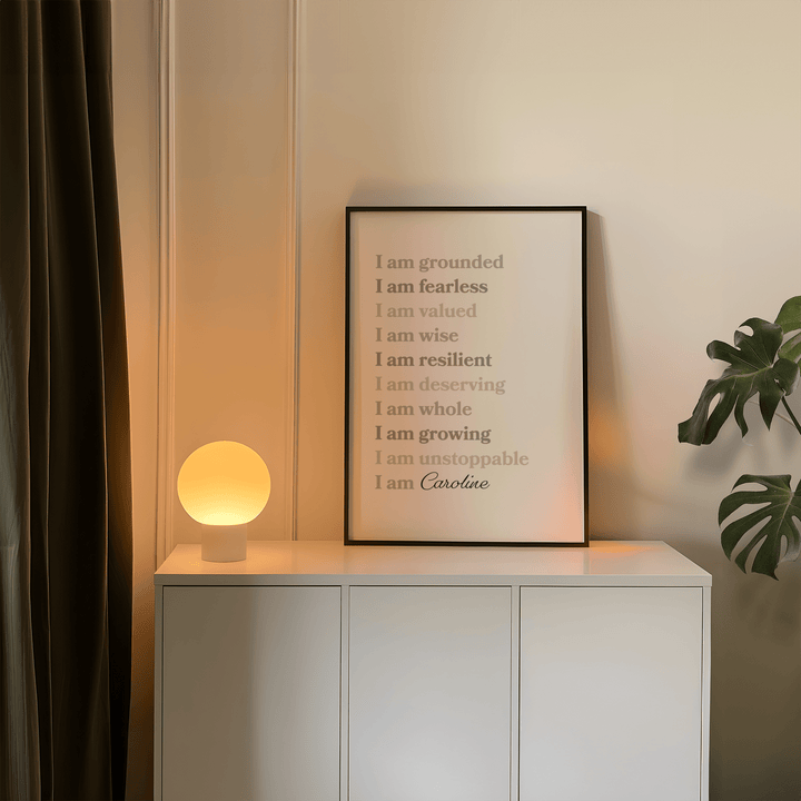 Framed Custom Quote Poster leaning on a white cupboard with a round lamp and plant nearby