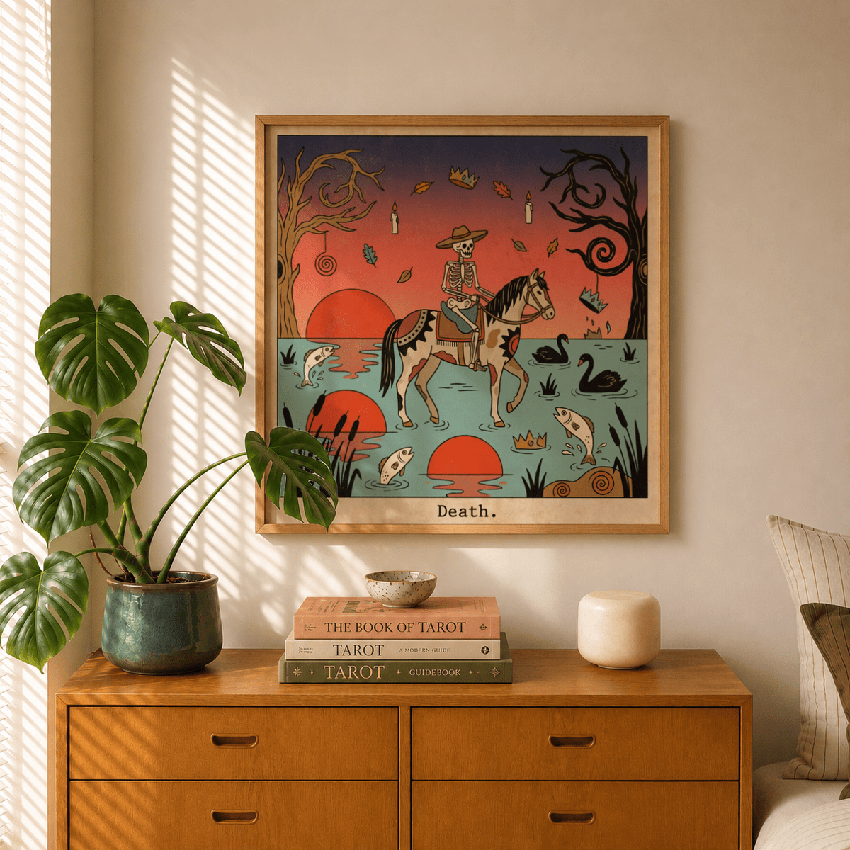 Death Tarot Card Art print of a skeleton riding a horse with red suns on a teal background on a dresser with plants