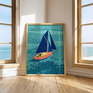 Print leaning on a floor by windows of a colorful sailboat poster with blue sails on a textured sea