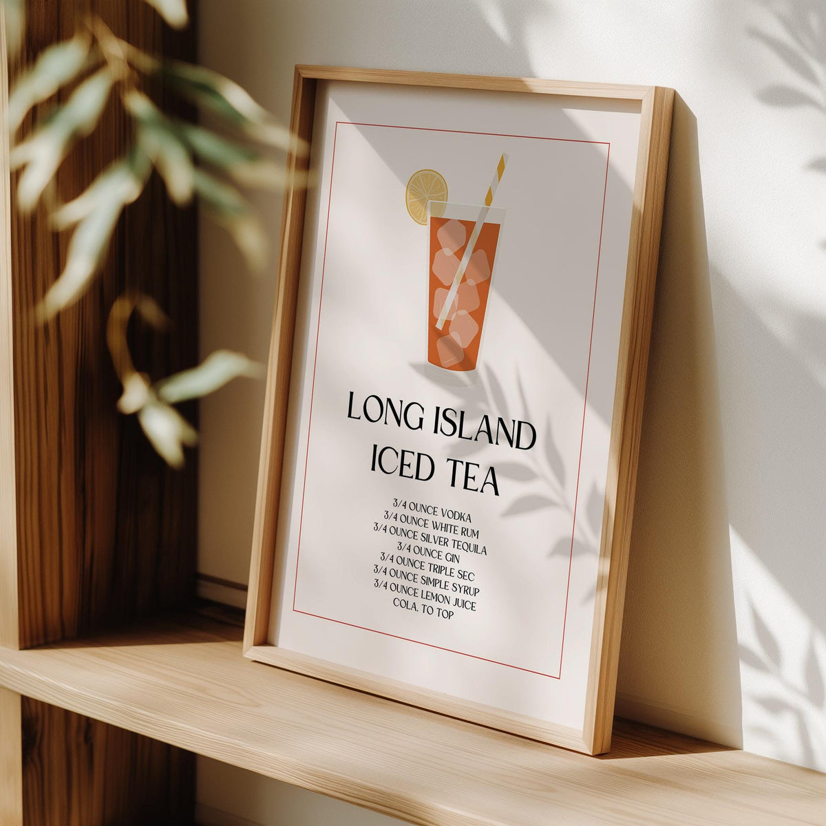 Print leaning on a wooden shelf showing a Long Island Iced Tea cocktail illustration with typographic recipe