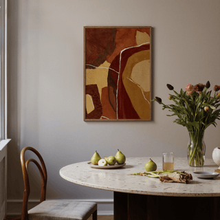 Abstract Earth Tones Print with brown and ochre shapes above a dining table with pears