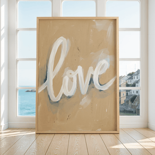 Love wall art leaning on a floor with ocean and buildings visible through tall windows