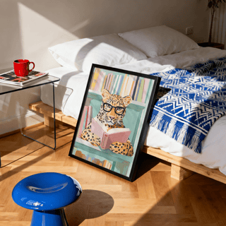 Print leaning on floor with Reading Leopard Art Print featuring a colourful illustration by a bed