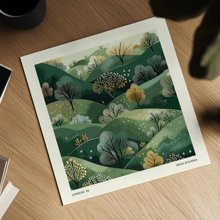 Close-up of large nature wall art showing green hills with trees placed on a wooden table with a black cup nearby