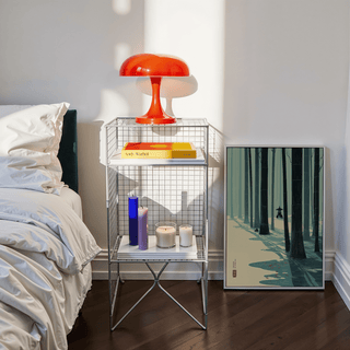 Print leaning on floor showing bamboo forest in green and cream shades beside bedside table with lamp