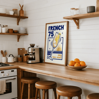 Print leaning on a kitchen shelf showing French 75 Poster with minimalist yellow and blue cocktail illustration and typography beside
