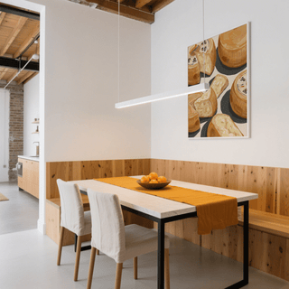 Print on a wall of parmesan cheese wheels and pieces in beige and brown tones in a dining room with a wooden table