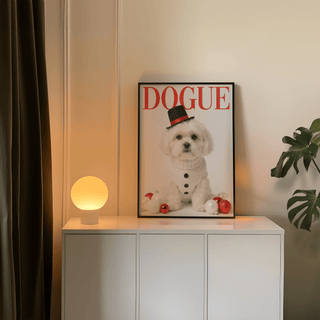 Christmas Shih Tzu Poster print leaning on a white sideboard next to a lit round lamp with a monstera plant nearby