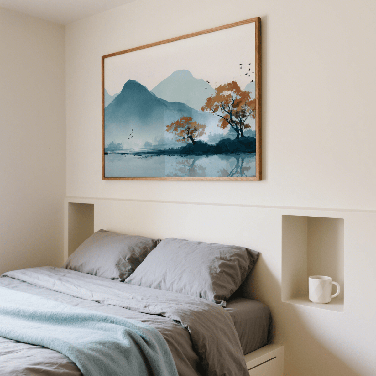 Nature wall art print of a misty mountain lake in blue and orange above a bed with grey bedding