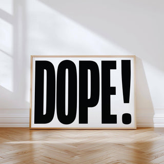Big Text Poster leaning on a wall with black dope typography on white background and wooden floor