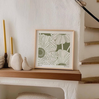 Sage Green Abstract Wall Art print leaning on a wooden shelf with decorative candles and ceramics