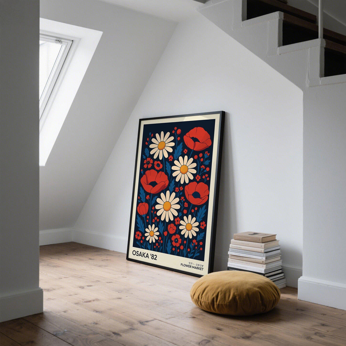 Print leaning on a floor in a loft space with red poppies and cream daisies near a stack of books