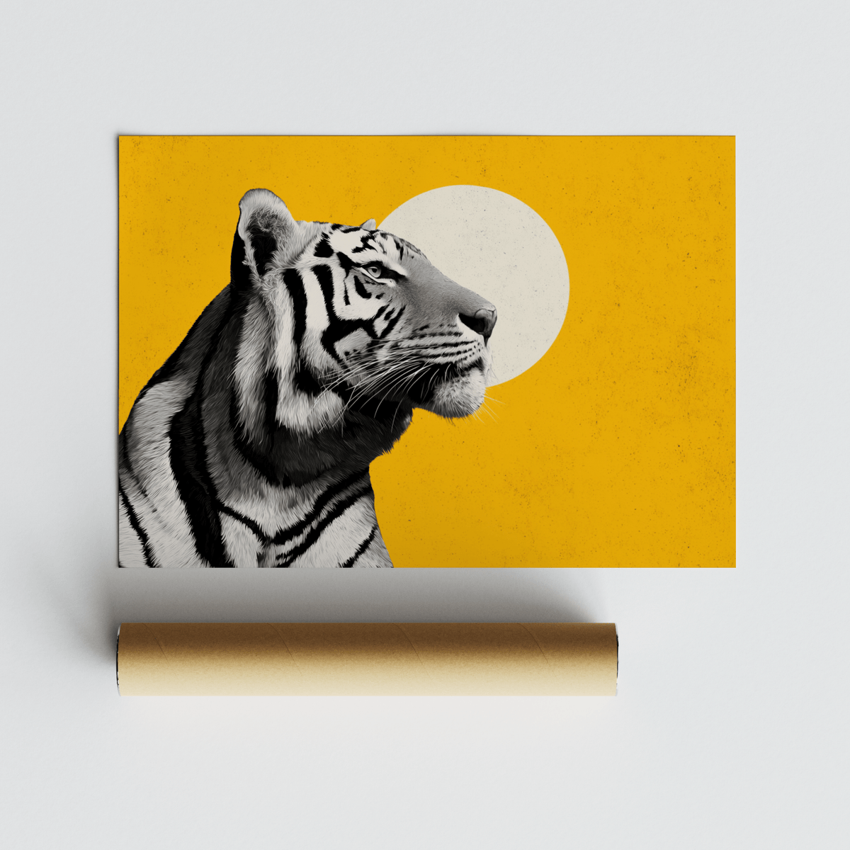 Tiger head profile in black and white on yellow background with a white circle against a grey surface with a packaging tube