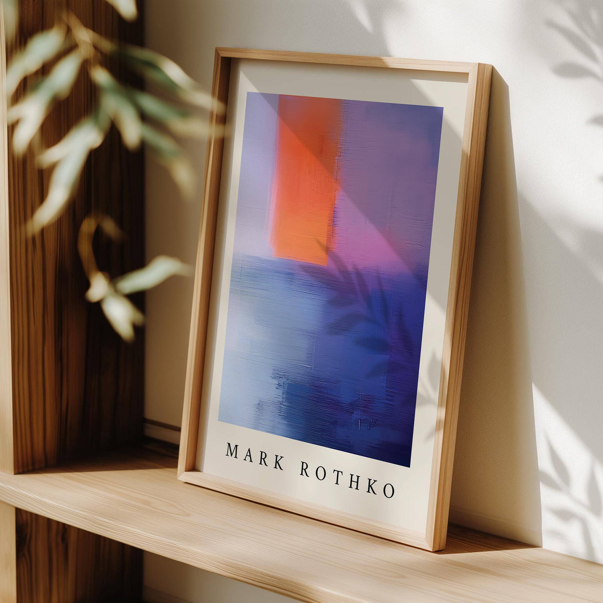 Print leaning on a shelf with Rothko Art abstract colour blocks in orange and blue with shadow of leaves