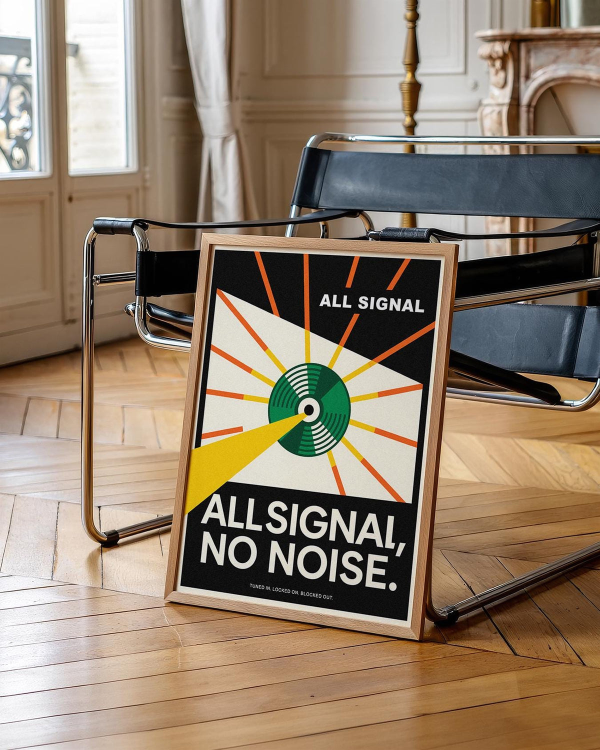 Framed Vinyl Record Poster leaning on black chair with wooden parquet floor visible