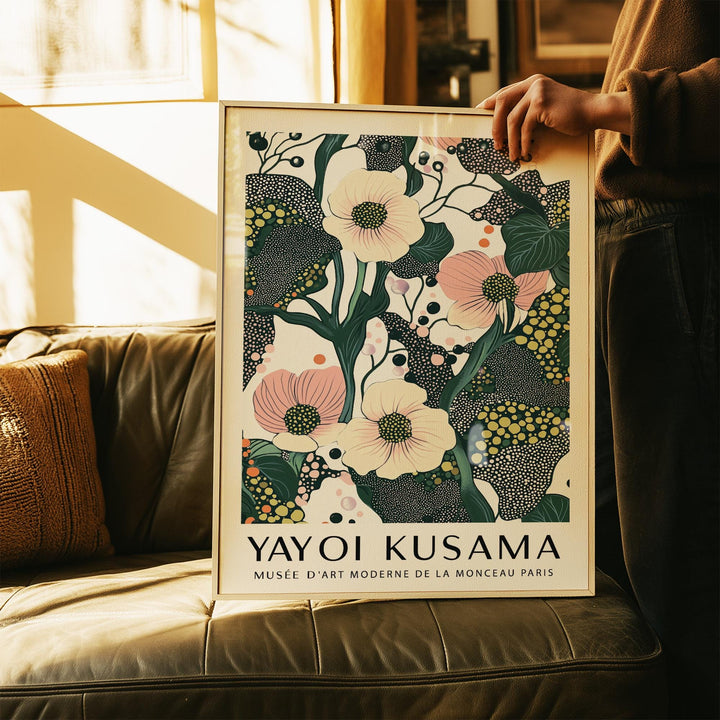 Framed green pink wall art with poppy flowers illustration held above a brown leather sofa