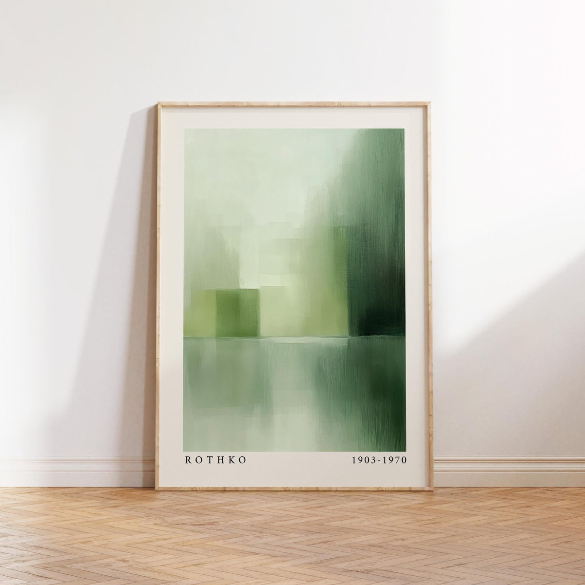 Green abstract wall art leaning on a wooden floor with light and shadow on a white wall