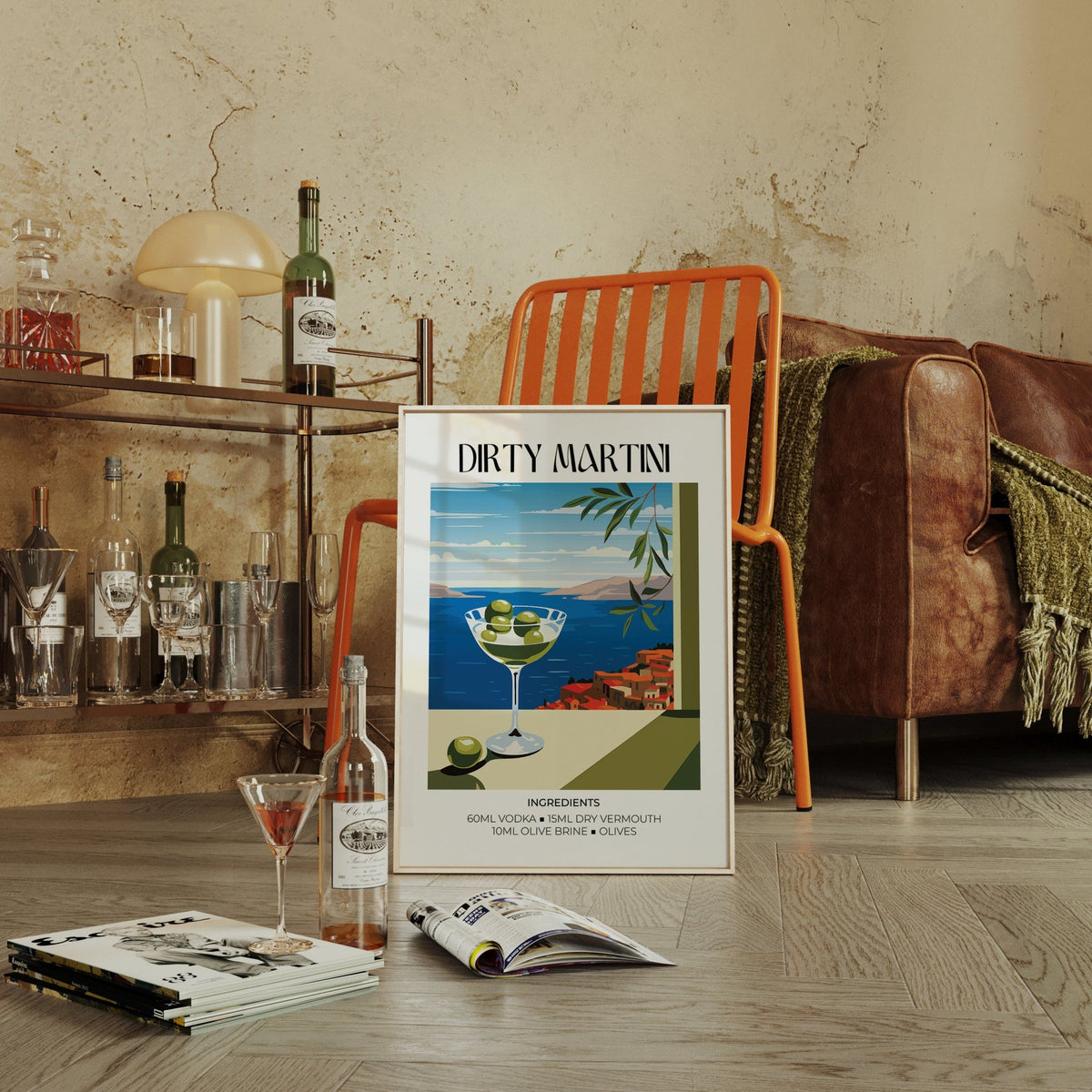 Print leaning on the floor showing a dirty martini illustration with a coastal view and orange chair nearby