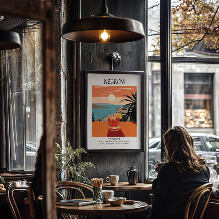 Print on a wall of a negroni cocktail glass illustration with orange and blue hues in a cafe setting