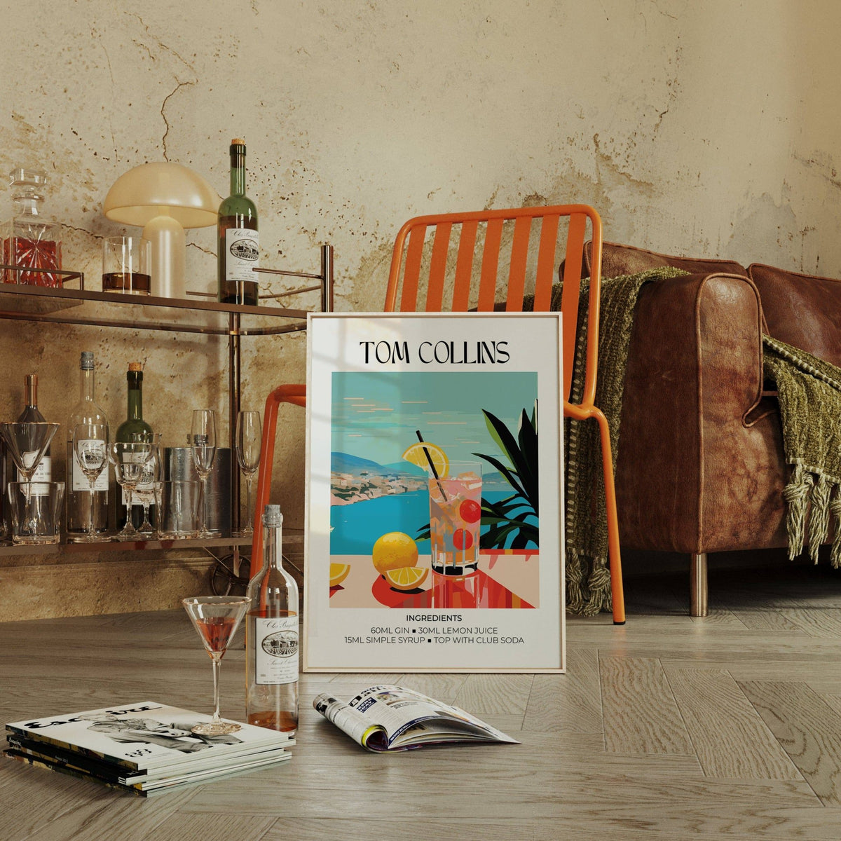 Artwork bar print of Tom Collins cocktail with mid-century colours leaning by an orange chair