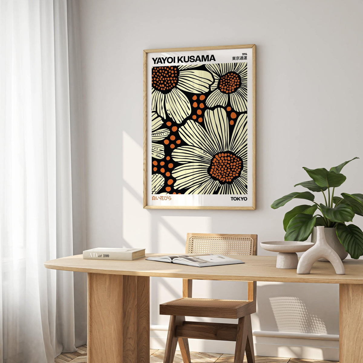 Modern Floral Art Print of large stylized daisies with cream and orange on black above a dining table with a decorative vase