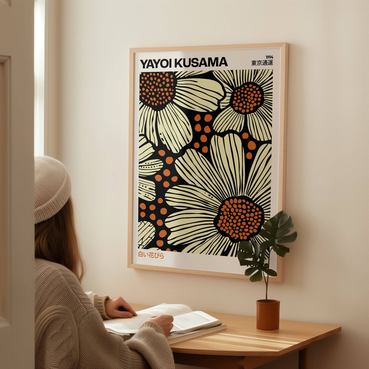 Modern Floral Art Print of large daisies in cream and orange tones above a desk with a potted plant