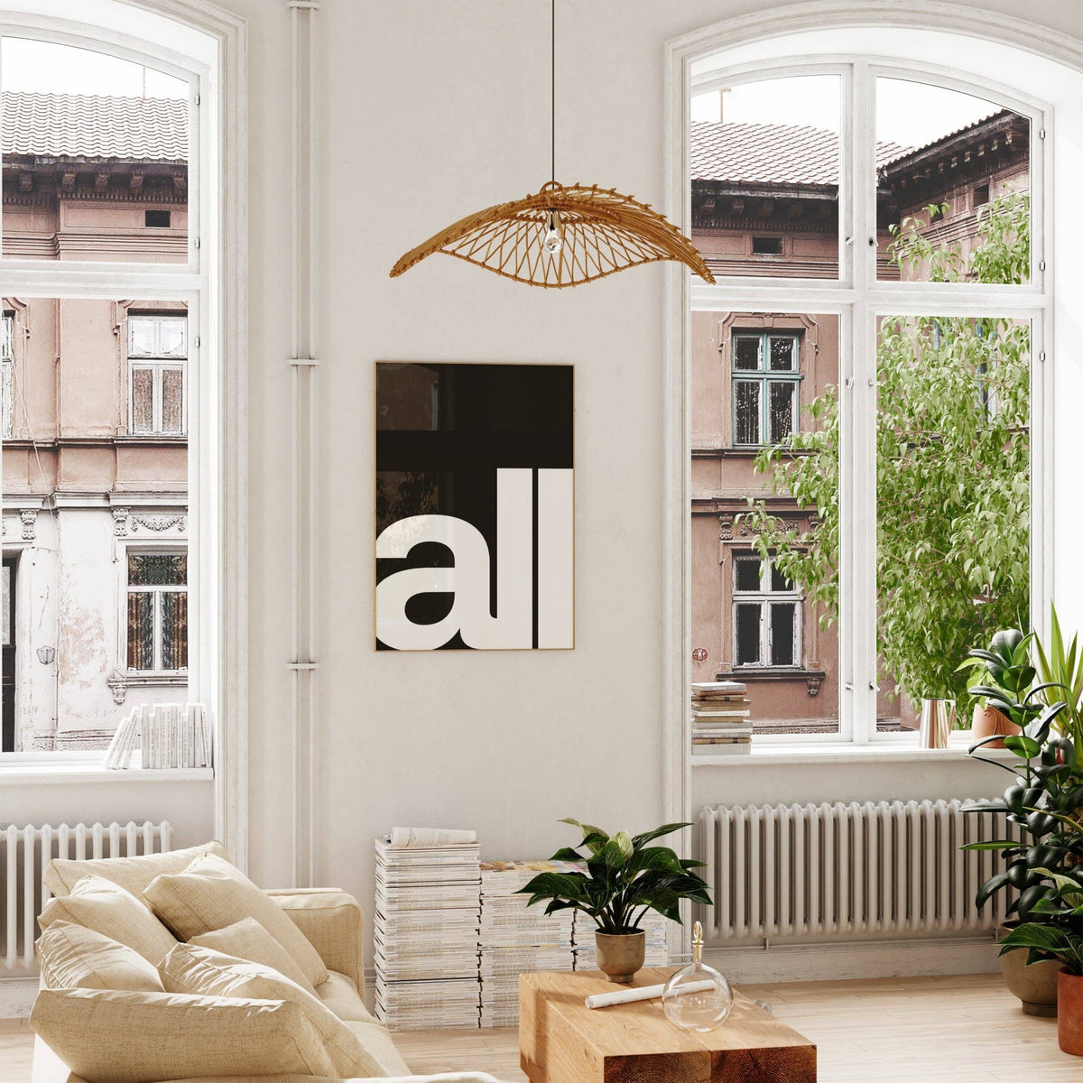 Typography art prints with black and white minimalist text hanging on a wall above a stack of books