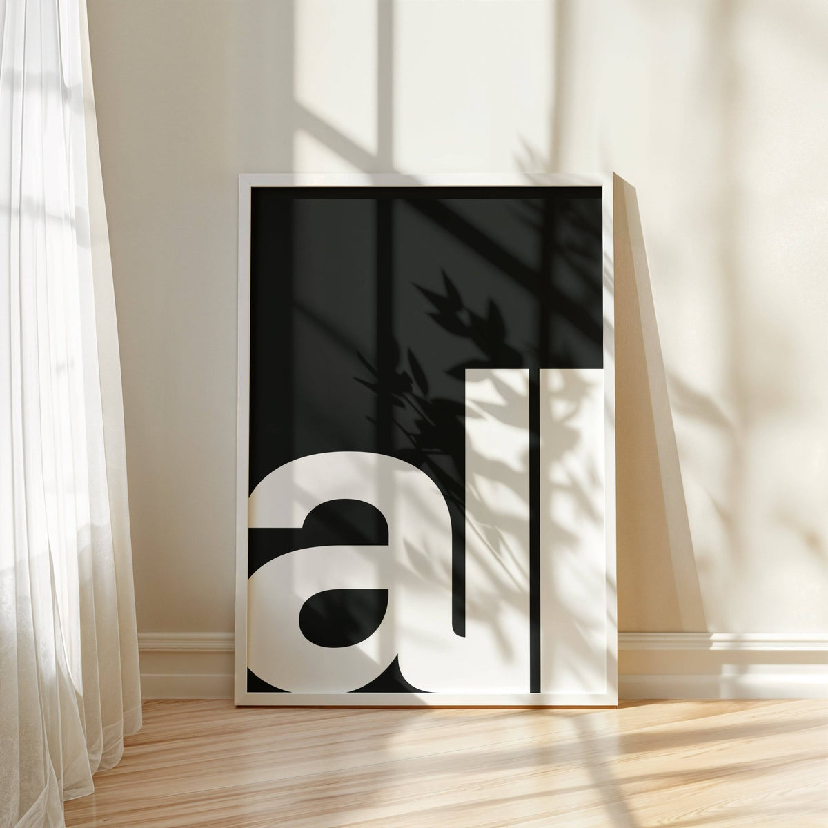 Print leaning on a floor with minimalist white text on black and natural light shadows
