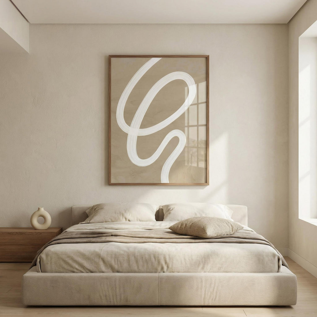 Large beige abstract print with a white looping line above a low upholstered bed in a calm neutral bedroom