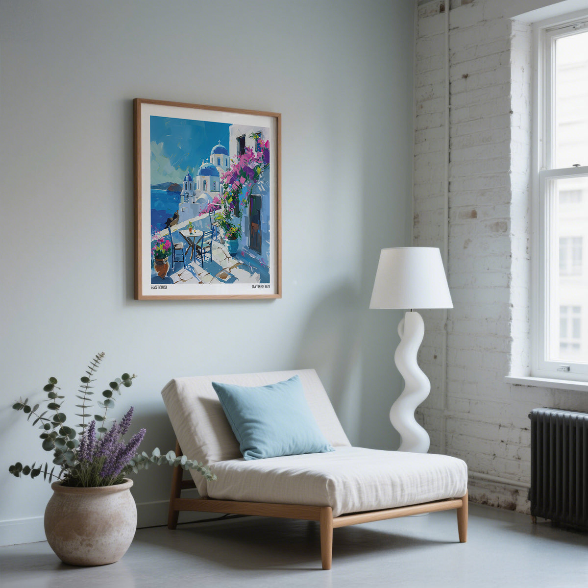 Santorini wall art print illustrating white and blue architecture above a cream chair with a blue cushion