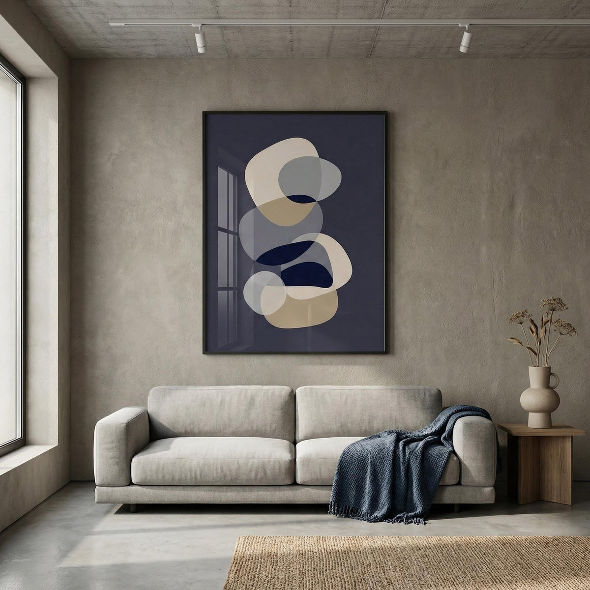 Abstract modern art wall art of overlapping neutral and blue shapes above a grey sofa in a living room