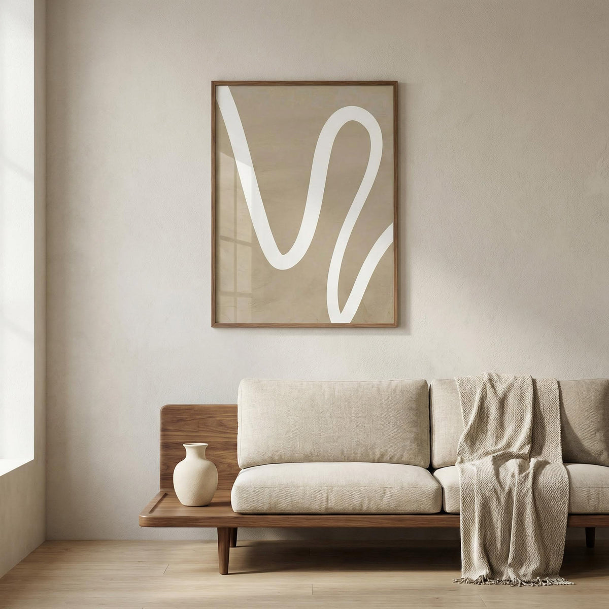 Beige wall art with a white wavy line above a wooden sofa with beige cushions and a vase