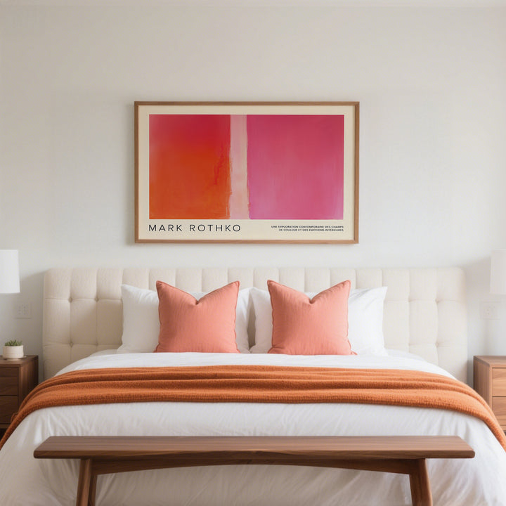 Color block wall decor with red and pink blocks above a bed with orange cushions