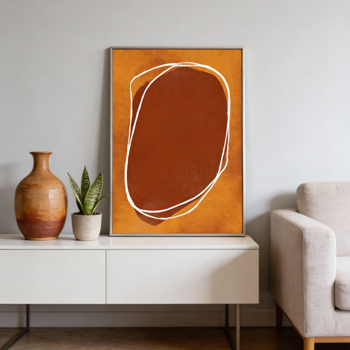 Abstract Earth Tone wall art with orange and brown organic shapes displayed on a white cabinet with plants and a vase