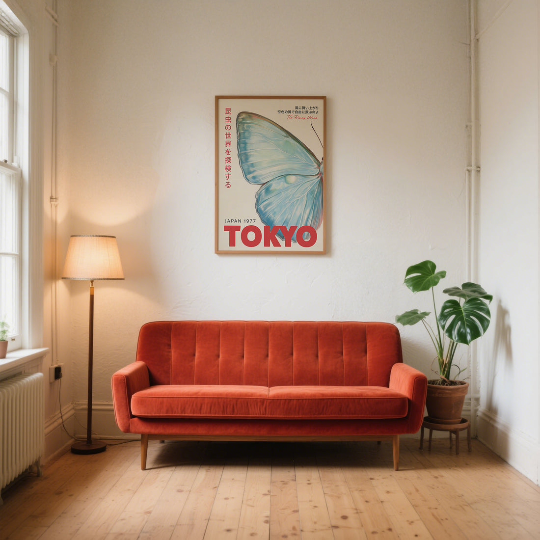Japanese butterfly print with red Tokyo lettering above an orange velvet sofa in a bright white living room with wooden floors