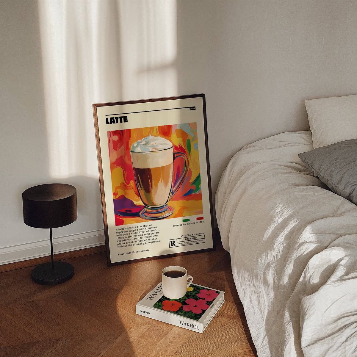 Coffee artwork prints leaning on floor with a latte illustration and vibrant background near a bed and lamp
