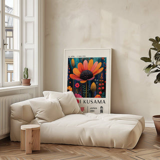Flower wall decor print leaning on floor with lively orange flower next to a green plant
