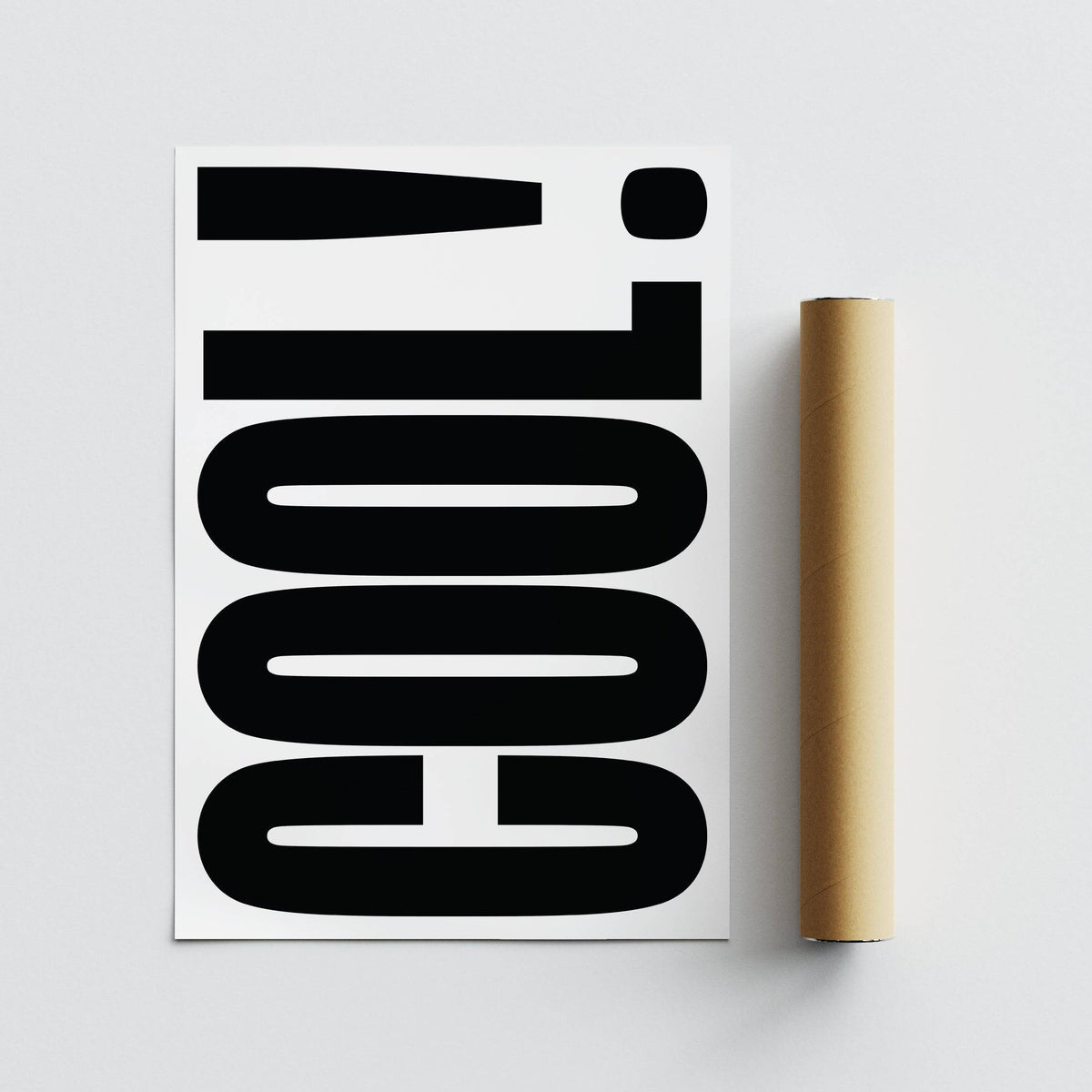 Close-up of Cool Typography Poster with black text on white alongside a brown packaging tube