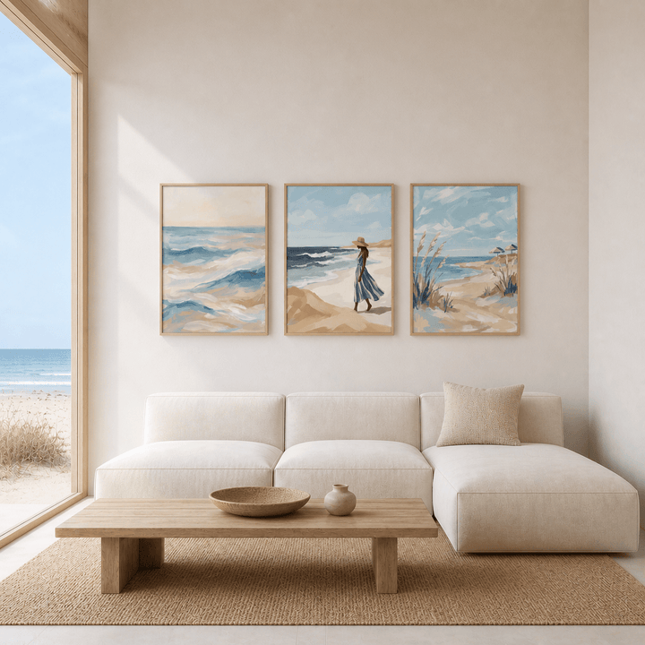 Coastal wall art set of three watercolour prints with beach and ocean scenes above a beige sofa