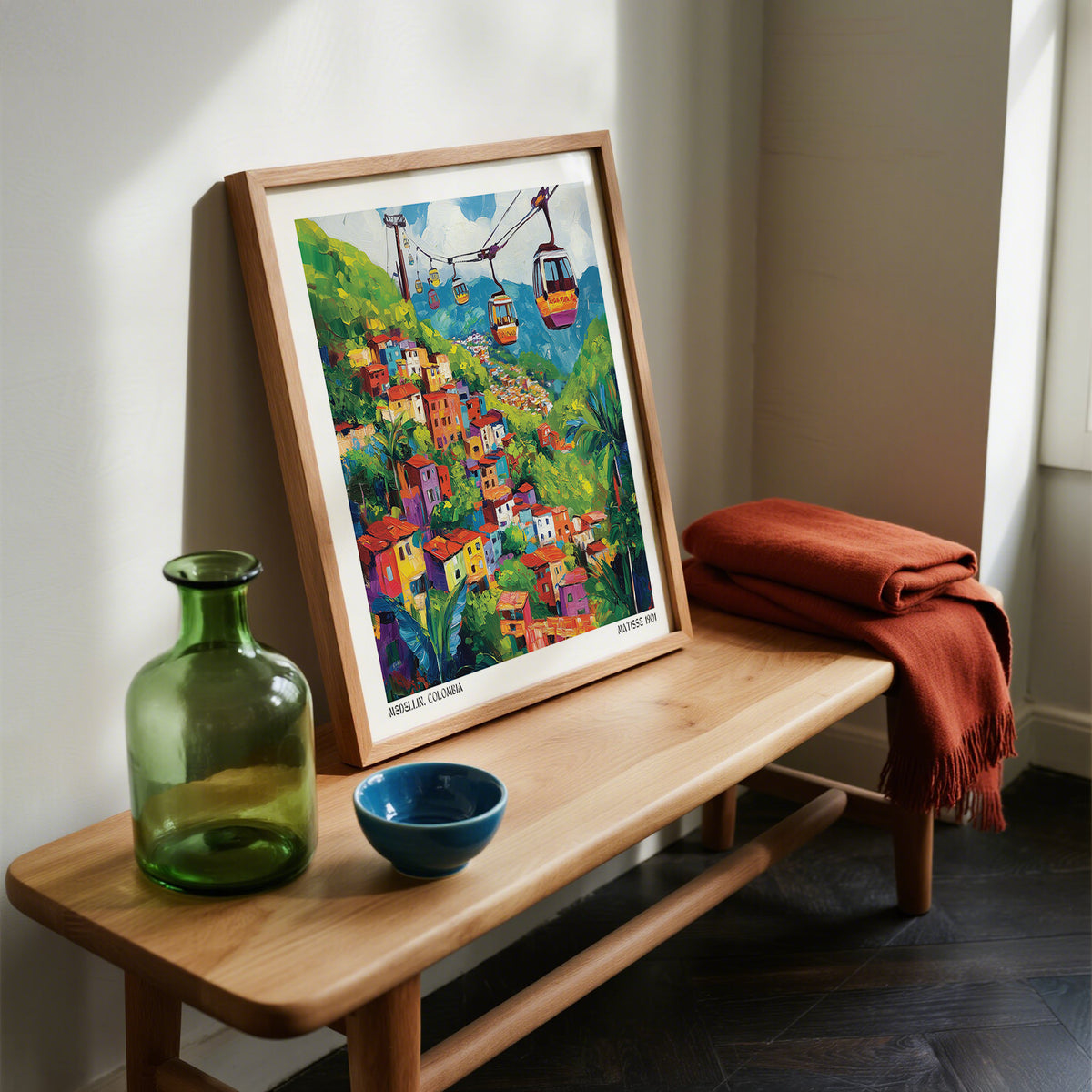 Framed Colombia Wall Art on a wooden bench with a green bottle and blue bowl.