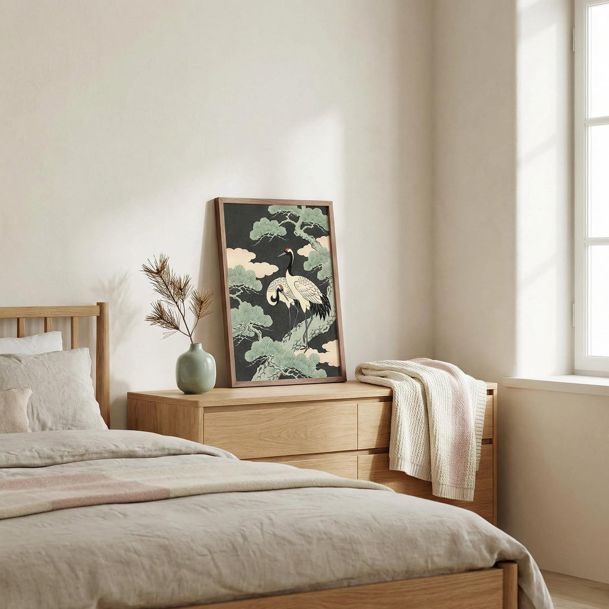 Print leaning on a wooden dresser of Japanese Crane Art Print showing cranes near a green tree in soft natural light