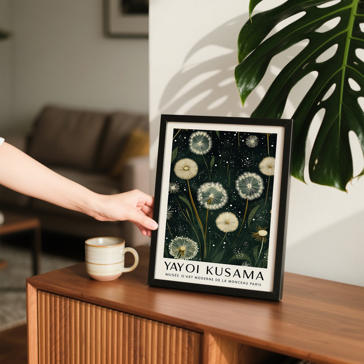 Framed dandelion print illustration in black frame with green leaves nearby