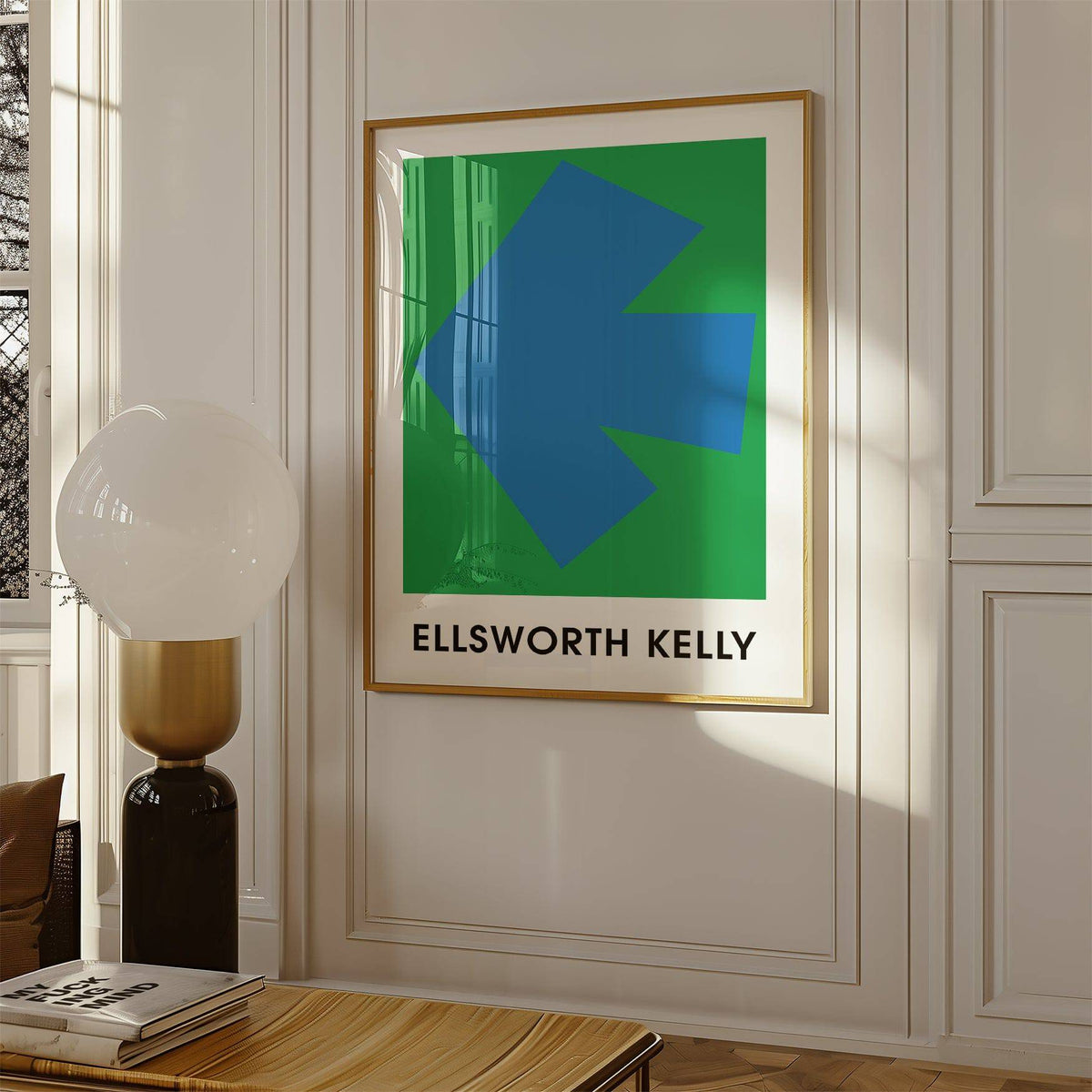 Ellsworth Kelly art print with a blue arrow shape on green background framed on a wall with a lamp nearby