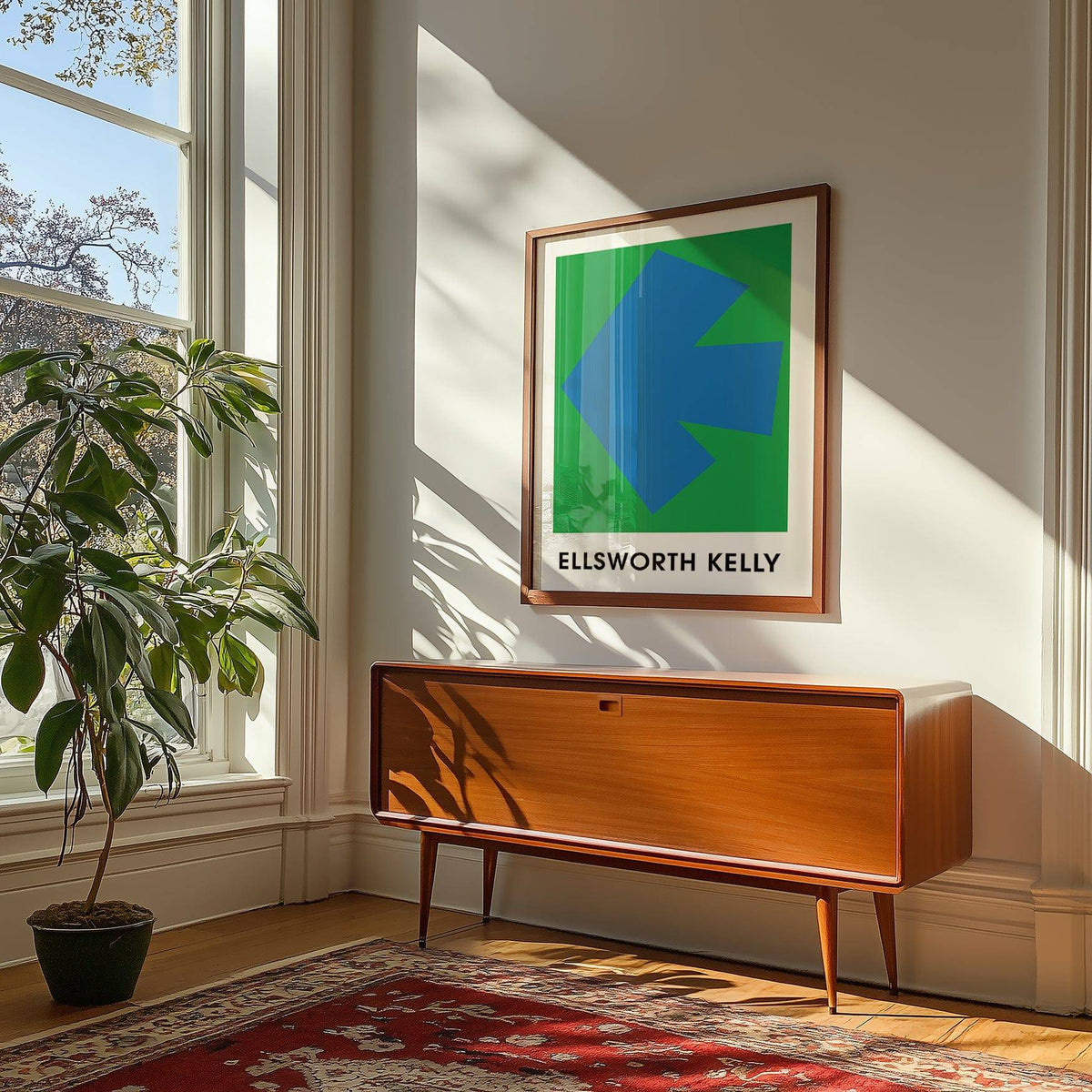 Ellsworth Kelly art print with a blue arrow shape on green above a mid-century wood cabinet and plant