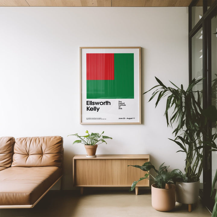 Office poster with red and green geometric shapes above a wooden sideboard with a plant